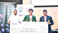 A QNB official presenting award to QCPC 2024 winners in high school track competition.