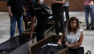 A woman mourns by the bodies of relatives killed on September 29 in an Israeli air strike on the town of Ain al-Delb, during their funeral in the nearby city of Sidon in southern Lebanon on October 1, 2024. Photo by Mahmoud ZAYYAT / AFP.