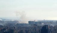 Smoke rises above buildings in Beirut's southern suburbs following an Israeli strike, on October 4, 2024. Photo by ETIENNE TORBEY / AFP.