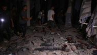 Palestinians use their telephone torches to search for the victims of an Israeli strike that targeted a mosque-turned-shelter in Deir al-Balah in the central Gaza Strip, during the night of October 6, 2024. Photo by BASHAR TALEB / AFP.