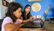 Noor Khawaja, 36, helps her seven-year-old daughter Jude study at their apartment in Beirut on October 5, 2024. Photo by AFP