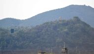 A North Korean guard post (R top) and a loudspeaker (L) on the North side of the Demilitarized Zone (DMZ) dividing the two Koreas, are seen over a South Korean guard post (bottom) from the border city of Paju on October 9, 2024. (Photo by Jung Yeon-je / AFP)
 