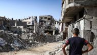 A man stands before a collapsed building in the Bureij camp for Palestinian refugees in the central Gaza Strip on October 9, 2024. (Photo by Eyad Baba / AFP)