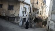 A Palestinian woman walks through the Jenin refugee camp on October 9, 2024 , in the Israeli occupied West Bank. (Photo by JOHN WESSELS / AFP)
