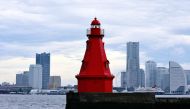 The Yokohama Kita Suitei Lighthouse, a century old and still a working lighthouse, is seen against the city skyline. (Photo by The Japan News)