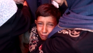 A Palestinian boy cries after an Israeli strike hit the Rafida school housing displaced people in Deir al-Balah in the central Gaza Strip on October 10, 2024.(Photo by Eyad Baba / AFP)