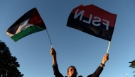 (Files) A man holds a Palestinian and Sandinista flags during the inauguration of Gaza street in support to the Palestinian people, in the historic center of Managua on January 30, 2024. (Photo by Oswaldo Rivas/ AFP)