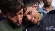 Ali Assaf (R), 20, reportedly the only survivor from his family killed in an overnight Israeli airstrike in the Jabalia refugee camp in the northern Gaza Strip, is comforted by a young man as mourns near the bodies of his relatives in front of the al-Maamadani on October 12, 2024. Photo by Omar AL-QATTAA / AFP.
