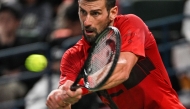 Serbia's Novak Djokovic hits a return to Italy's Jannik Sinner during their men's singles final match at the Shanghai Masters tennis tournament in Shanghai on October 13, 2024. (Photo by Hector Retamal / AFP)