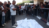 Palestinians pray over the bodies of relatives, killed in an Israeli strike on Al-Bureij refugee camp, during their funeral at the al-Aqsa Martyrs hospital in Deir al-Balah in the central Gaza Strip on October 13, 2024. (Photo by Eyad Baba / AFP)