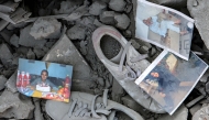 Personal photograph prints and sneaker shoes are strewn through the rubble of a destroyed building in the aftermath of an overnight Israeli air strike on the village of Qana in southern Lebanon on October 16, 2024. (Photo by Bilal Kashmar / AFP)