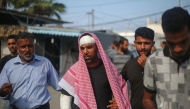 Injured Palestinian Ahmed al-Dalu, who survived an Israeli airstrike on tents for displaced people two days earlier which killed his wife and son Shaaban in the courtyard of Al-Aqsa Martyrs Hospital, walks in front of the medical facility in Deir al-Balah in the central Gaza Strip, on October 16, 2024. (Photo by Eyad BABA / AFP)