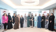 QBWA Vice Chairwoman Aisha Alfardan and EWA Founder and President Yulia Stark pose for a group photo with other officials.