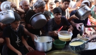 Displaced Palestinians queue to receive food rations, offered by a charity, in Gaza's Al-Shati refugee camp on October 17, 2024. Photo by Omar AL-QATTAA / AFP