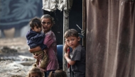 Palestinian children stand next to tents at a make-shift camp for the internally displaced in Deir al-Balah in the central Gaza Strip on October 17, 2024. Photo by Eyad BABA / AFP.
