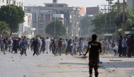 Students hurl stones towards security personnel during a demonstration to condemn the alleged rape of a female student in Rawalpindi on October 17, 2024. (Photo by Ghulam Rasool / AFP)