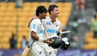 New Zealand's Will Young (R) and Rachin Ravindra celebrate their team's win against India at the end of their first Test cricket match in the M. Chinnaswamy Stadium of Bengaluru on October 20, 2024. (Photo by Idrees Mohammed / AFP) 