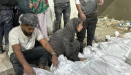 Palestinians mourn over the covered bodies of relatives, killed in an Israeli airstrike, outside the Kamal Adwan Hospital in Beit Lahia, in the northern Gaza Strip on October 19, 2024. Photo by Islam AHMED / AFP.
