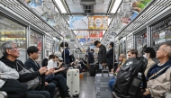 People ride on the Tokyo Metro underground system in central Tokyo on October 21, 2024. (Photo by Richard A. Brooks / AFP)
