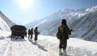 File: Indian army soldiers walk along a road near Zojila mountain pass that connects Srinagar to the union territory of Ladakh, bordering China on February 28, 2021. (Photo by Tauseef Mustafa / AFP)