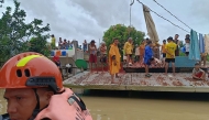 This handout photo taken and released on October 23, 2024 by the Philippine Coast Guard (PCG) shows residents affected by Tropical Storm Trami standing on the roofs of their submerged houses before being evacuated, in Libon town, Albay province, South of Manila. (Photo by Handout / Philippine Coast Guard (PCG) / AFP) 