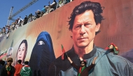 File: A tarp image of former Prime Minister Imran Khan and wife Bushra Bibi during a rally in Islamabad on September 8, 2024. (Photo by Farooq Naeem / AFP)

