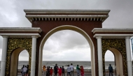 Tourists walk along a beach as dark clouds loom over the sky in Digha around 220 km southwest of Kolkata, on October 25, 2024, after cyclone Dana hits the coasts of India's West Bengal and Odisha states. Photo by DIBYANGSHU SARKAR / AFP