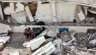 Displaced Palestinian children sit amid the rubble of a destroyed building in the Nasser district of Gaza City, in the northern Gaza Strip on October 25, 2024. (Photo by Omar Al-Qattaa / AFP)