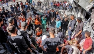 Palestinian civil defence members search for survivors and victims through the rubble following Israeli bombardment on the four-storey Muqat family house in the Zarqa neighbourhood in the north of Gaza City on October 26, 2024 amid the ongoing war in the Palestinian territory between Israel and Hamas. (Photo by Omar AL-QATTAA / AFP)
