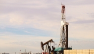 A pumpjack and drilling rig in Midland, Texas.