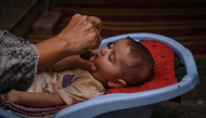 A health worker administers polio drops to a child during a door-to-door vaccination campaign in Karachi on October 28, 2024. Photo by Rizwan TABASSUM / AFP.
