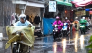 People ride scooters in heavy rain as Typhoon Kong-rey approaches Taiwan, in Yilan County on October 30, 2024. (Photo by I-Hwa CHENG / AFP)