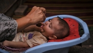 A health worker administers polio drops to a child during a door-to-door vaccination campaign in Karachi on October 28, 2024. Photo by Rizwan Tabassum / AFP.

