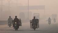 Commuters make their way amid smog in Lahore on November 2, 2024. (Photo by Arif ALI / AFP)
