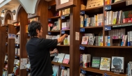 This photo taken on August 1, 2024 shows Rokurou Yui, president of book review site All Reviews and president of three shelf-sharing bookstores, working at his bookstore in Tokyo's Kanda Jimbocho district, one of the world's largest 