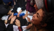 Relatives mourn over the bodies of Mahmoud Foura and his son Saad Foura who were killed during overnight Israeli bombardment, as they are prepared for burial at Al-Aqsa Martyrs hospital in Deir el-Balah in the central Gaza Strip on November 3, 2024. (Photo by Eyad Baba / AFP)