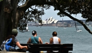 Visitors spend their morning under a large tree at Bradleys Head in Sydney, overlooking the Opera House on November 3, 2024. (Photo by Saeed Khan / AFP)
 