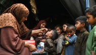 Health workers administer polio drops to children during a door-to-door vaccination campaign in Lahore on October 28, 2024. Photo by Arif ALI / AFP.