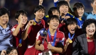 North Korea's players celebrate with the trophy after winning the FIFA U-17 women's football World Cup 2024 final match between North Korea and Spain at the Olimpico Felix Sanchez Stadium in Santo Domingo on November 3, 2024. (Photo by Nelson Pulido / AFP)