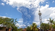 Schoolchildren run during the eruption of Mount Lewotobi Laki-Laki, as seen from Lewolaga village in East Flores, East Nusa Tenggara on November 7, 2024. (Photo by ARNOLD WELIANTO / AFP)