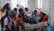 In this photograph taken on November 4, 2024, Naeem (R), a schoolboy, gets treatment for dengue as his friends visit him inside a children's ward in Shaheed Suhrawardy Medical College and Hospital in Dhaka. Photo by Abdul Goni / AFP