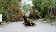 In this handout photo from Nathan Tamayo taken and received on November 8, 2024, a man picks up a debris in the aftermath of Typhoon Yinxing in Ballesteros, province of Cagayan. (Photo by Nathan Tamayo / AFP)