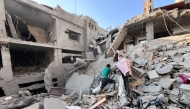 A Palestinian man searches for missing family members under the rubble outside the Assi building which was destroyed in Israeli bombardment in Beit Lahia in the northern Gaza Strip on November 7, 2024. (Photo by AFP)