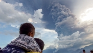 Residents watch the eruption of Mount Lewotobi Laki Laki from Eputobi village in Titihena, East Nusa Tenggara, on November 8, 2024. (Photo by Bayu Ismoyo and Arnold Welianto / AFP)