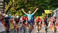 Britain's Mark Cavendish (C) celebrates as he crosses the finish line during the third Tour de France Singapore Criterium race in Singapore on November 10, 2024. (Photo by Roslan Rahman / AFP)