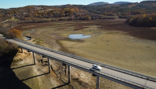 Photo used for demonstration purposes. A car rides by the dried Yovkovtsi dam, near the town of Elena, Central Bulgaria on November 08, 2024. Nine of 12 dams supplying water to localities in Bulgaria are 65% full, and the drought in summer is perduring now in the autumn. More than 240.000 people in a country of 6,5 million are facing regular water shortages. Photo by Nikolay DOYCHINOV / AFP.