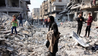 Palestinians walk amid the destruction following an Israeli strike in Jabalia in the northern Gaza Strip on November 10, 2024. (Photo by Omar Al-Qattaa / AFP)

