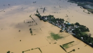 An aerial photo shows a swollen river inundating farm fields and houses at a village in Ilagan town, Isabela province on November 12, 2024, a day after Typhoon Toraji hit the province. (Photo by Villamor Visaya / AFP)