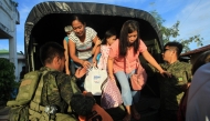 Residents get off a truck after the local government implemented a preemptive evacuation in Daraga, Albay on November 15, 2024, ahead of the landfall of Typhoon Man-Yi. Photo by Charism SAYAT / AFP