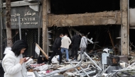 People inspect the damage to a building, targeted in an Israeli airstrike the previous day, in Beirut's Mar Elias Street on November 18, 2024. (Photo by Anwar Amro / AFP)